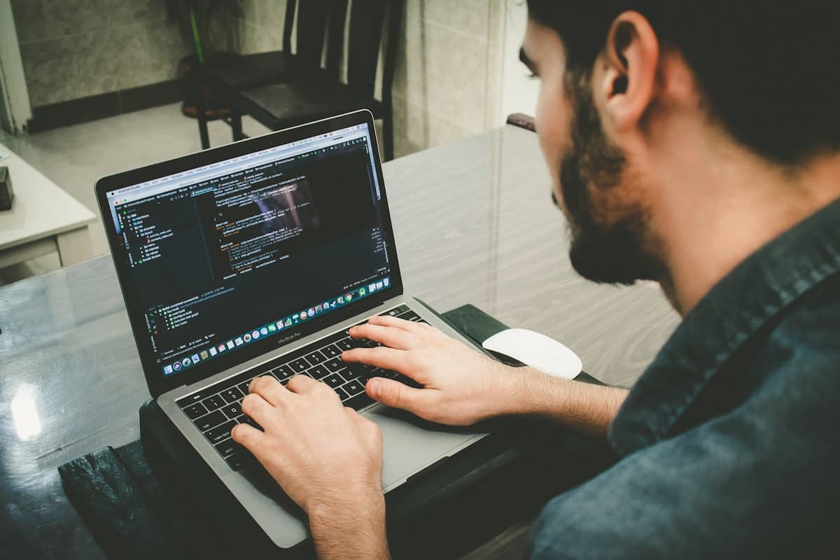 Desenvolvedor trabalhando com código em laptop — revisão crítica de código gerado por IA